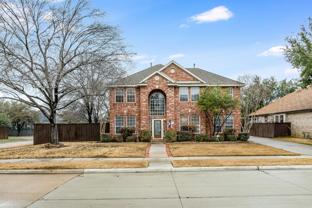 Two-story brick house with a large front lawn