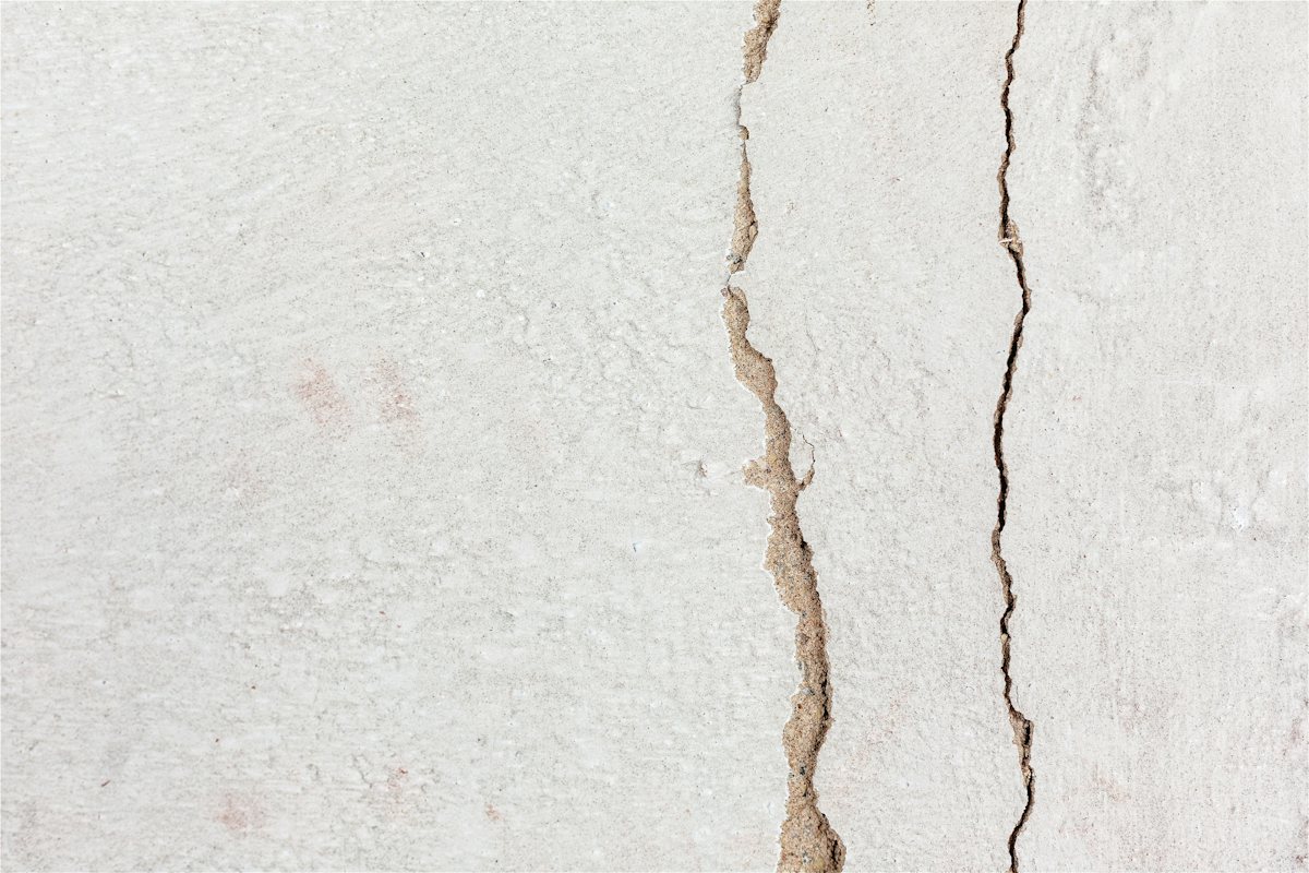 Painted white wall with thin cracks running across it