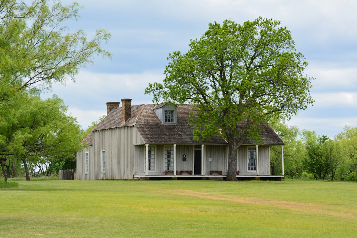 Weathered wood-frame house with a wraparound porch